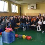 Grupa ludzi siedzi na widowni.