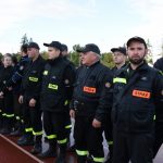 Grupa strażaków stojących na stadionie.