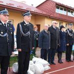 Grupa kobiet oraz mężczyzn stojących na baczność, ubranych odświętnie.