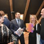 Dwie kobiety i dwóch mężczyzn w średnim wieku romzawiających ze sobą. W tle ściana poddasza.