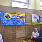 Dwa banery firm wiszą na drabinkach na sali gimnastycznej.