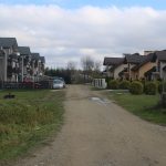 Dziurawa droga błonista pomiędzy budynkami.