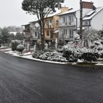 Ulica z nową nawierzchnią asfaltową, obok domki jednorodzinne.