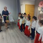 Dwie starsze kobiety dziękują dzieciom za przedstawienie i częstują icvh cukierkami.