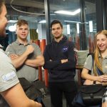 Młode osoby, chłopcy i dziewczyna rozmawiają w pomiszeczeniu,.