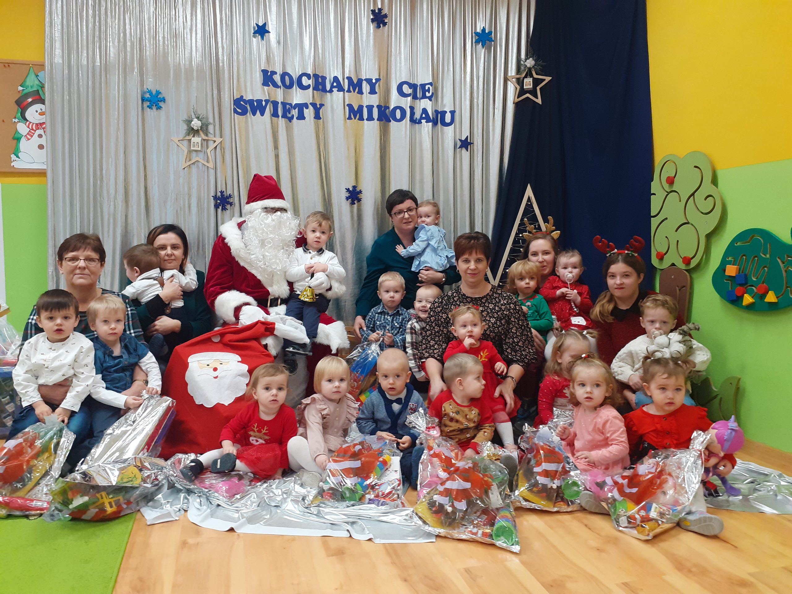 Grupa dzieci pozuje do zdjęcia z Mikołajem.