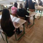 Grupa nastoletnich dziewczyn siedzaca w klasie.