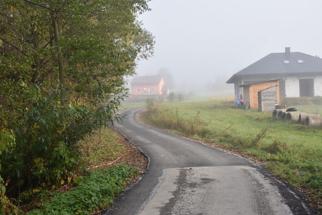 Droga asfaltowa między zabudową mieszkalną.