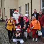 Grupa dzieewczyn pozuje do zdjęcia z mężczyzną przebranym za mikołaja oraz dwoma mężczyznami.