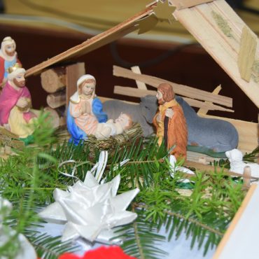 Szopka, a w niej małe figurki kobiety i mężczyzny i małego dzieciątka.