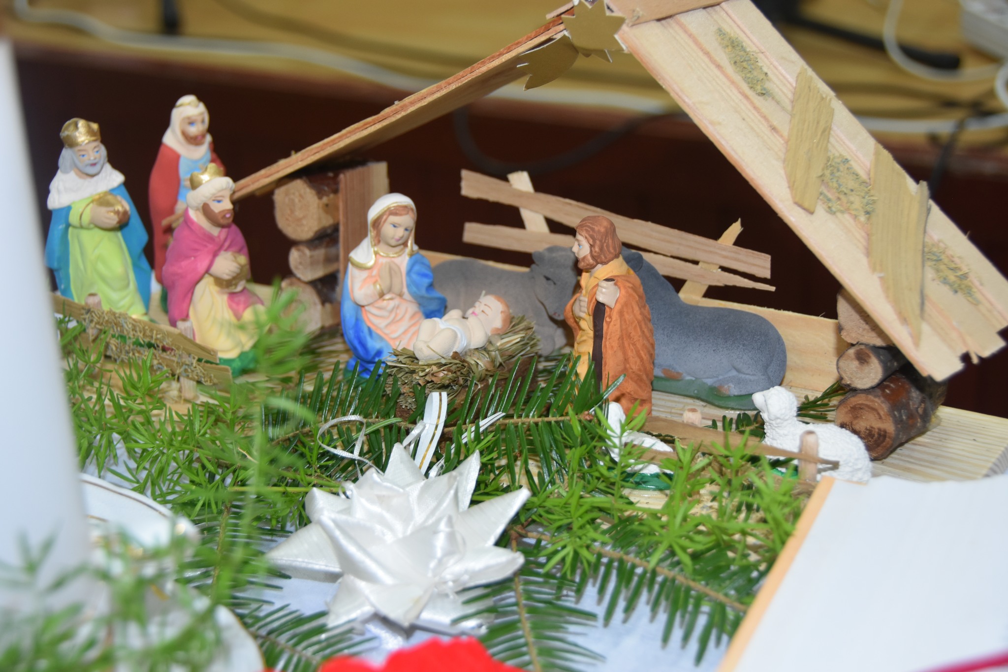 Szopka, a w niej małe figurki kobiety i mężczyzny i małego dzieciątka.