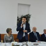 Młody mężczyzna w garniturze przemawia do zaebranych.