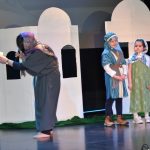 Grupa dzieci w storojach jasełkowych w czasie przedstawienia na scenie.