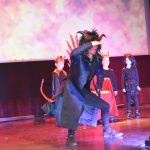 Mężczyzna i grupa dzieci przebranych za diabłów w czasie przedstawienia jasełkowego.