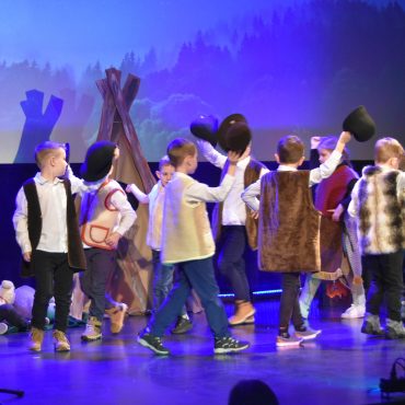 Grupa dzieci w strojach jasełkowych wystepuje na scenie.