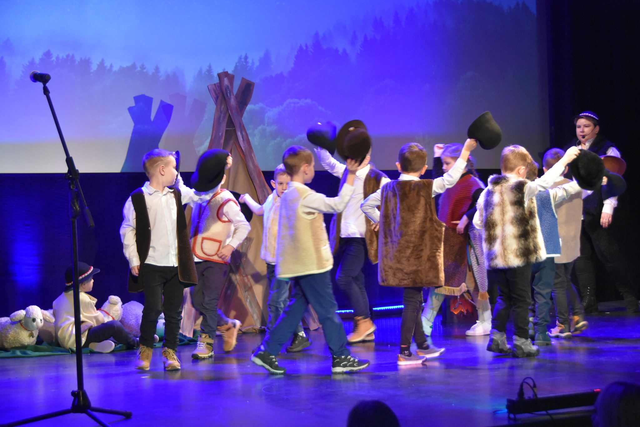 Grupa dzieci w strojach jasełkowych wystepuje na scenie.