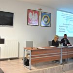 Kobieta i mężczyzna zasiadający na prezydium sali konferencyjnej.