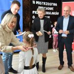 Grupa dorosłych w eleganckich strojach strojach odznaczających dzieci. medalami i upominkami