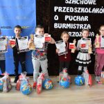 Trójka chłopców i trójka dziewcząt pozująca ze statuetkami i upominkami z okazji zawodów szachowych.