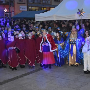 Grupa osób stoi na rynku podczas wydarzenia imprezowego.