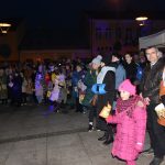 Grupa osób stoi na rynku podczas wydarzenia imprezowego.