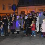 Grupa osób stoi na rynku podczas wydarzenia imprezowego.