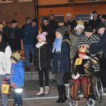 Grupa osób stoi na rynku podczas wydarzenia imprezowego.