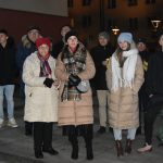 Grupa osób stoi na rynku podczas wydarzenia imprezowego.