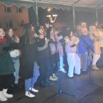 Grupa dzieci spiewa na scenie.