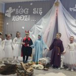 Grupa dzieci przebrana w stroje na sali przedszkolnej przedstawia.