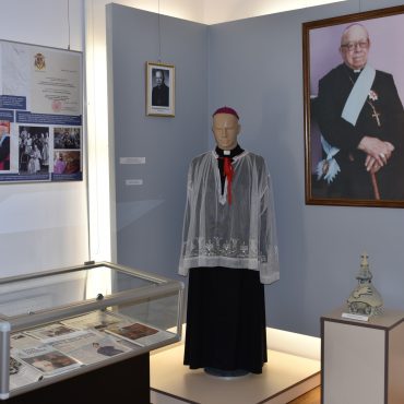 W jasnej sali wyłożone ekspozyty muzealne.