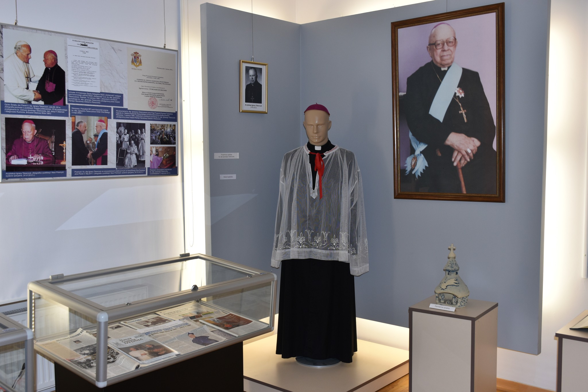 W jasnej sali wyłożone ekspozyty muzealne.