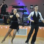 Młodzi mężczyzna i kobieta tańcząca na parkiecie. W tle scena.