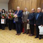 Grupa osób w oficjalnych stroajach i mundurach stojąca na sali konferencyjnej.