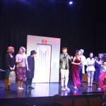 Grupa aktorów w sztuce grająca na scenie.