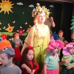 Kobieta ubrana w strój pani wiosny wraz z dziećmi ubranymi w wiosenne stroje.