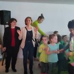 Grupa dorosłych i dzieci na salce teatralnej.