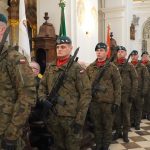 Mężczyźni w mundurach trzymający broń i stojący w rzędzie