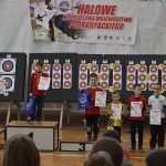 Grupa młodych chłopców łuczników pozujacych z dyplomami do zdjęcia.