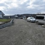 Droga utwardzona na której stoją trzy samochody.