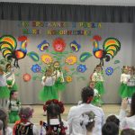 Grupa dziewczynek podczas występu tanecznego. Ogląda ich grupa dzieci.