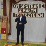 Mężczyzna w garniturze przemawiajacy za pomocą mikrofonu. Z tyłu napis XVI Spotkanie z Małym Teatrzykiem.