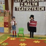 Dwóch młodych chłopców podczas wystepu teatralnego. Z tyłu widać napis XVI Spotkanie z Małym Teatrzykiem.