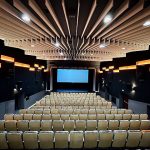 Sala kinowa z ekranem i miejscami siedzącymi