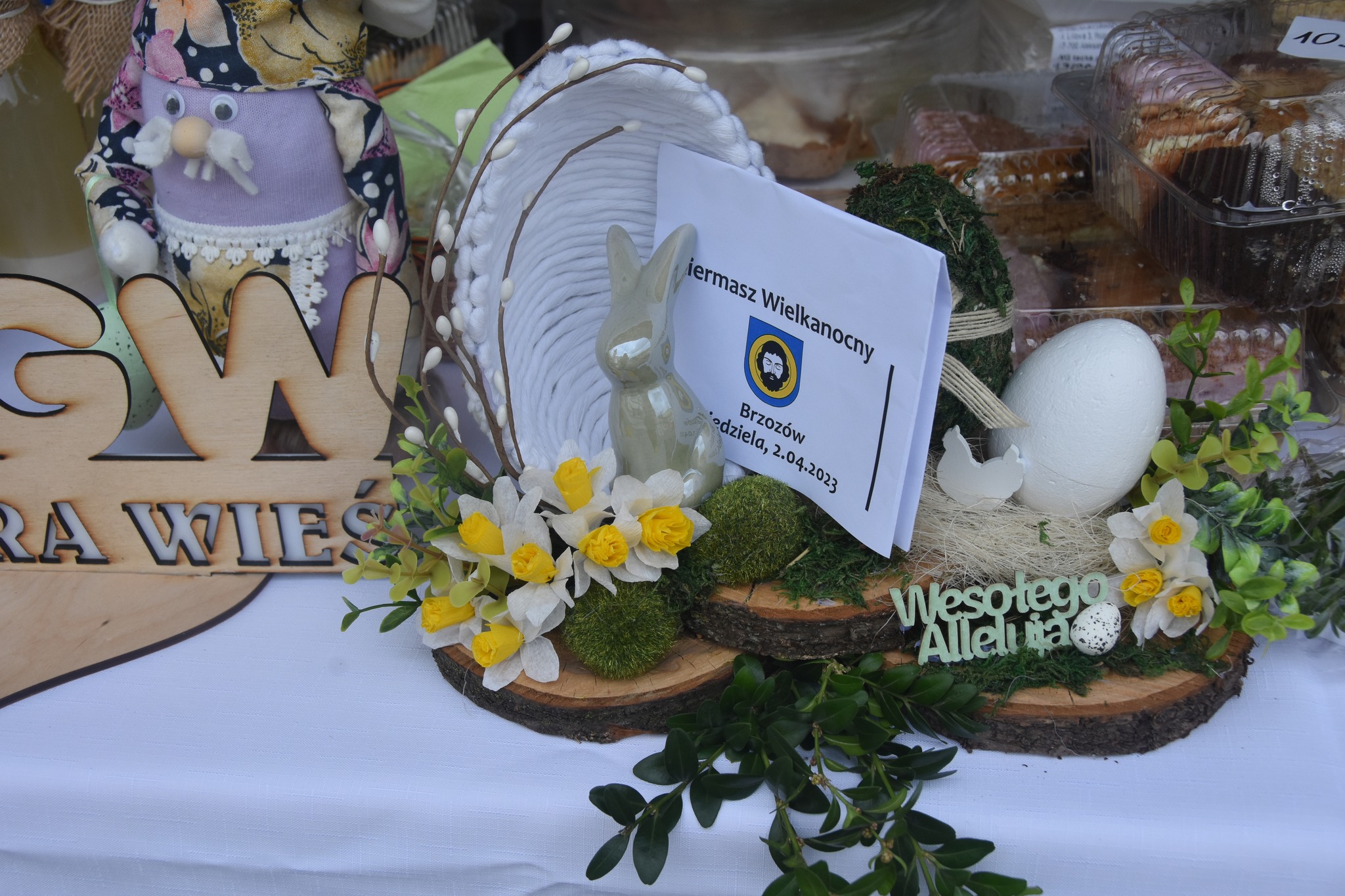 Wypieki i ozdoby na kiermaszu wielkanocnym zaprezentowane na stole.