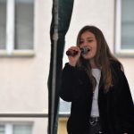 Dziwczyna śpiewajaca na scenie na rynku.