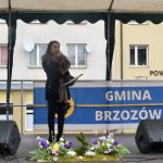 Dziwczyna śpiewajaca na scenie na rynku.