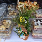 Ozdoby i wypieki na kiermaszu wielkanocnym zaprezentowane na stole.