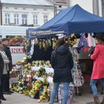 Duża grupa osob na kiermaszu wielkanocnym ogląda stoisko kiermaszu wielkanocnego.