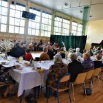 Grupa ludzi siedząca przy zastawionym stole